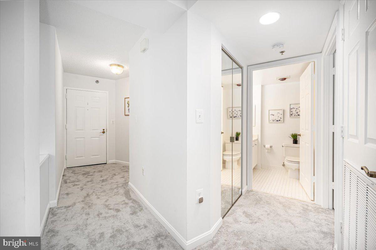 14805 Pennfield Circle, Unit 201 Silver Spring, MD 20906 - Photo 29 of 47 a view of a hallway with wooden floor and a bathroom