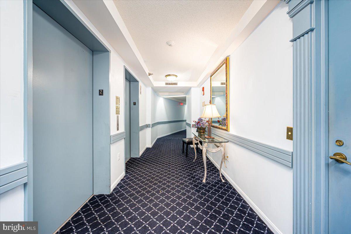 14805 Pennfield Circle, Unit 201 Silver Spring, MD 20906 - Photo 33 of 47 a hallway with a dining table and a stove