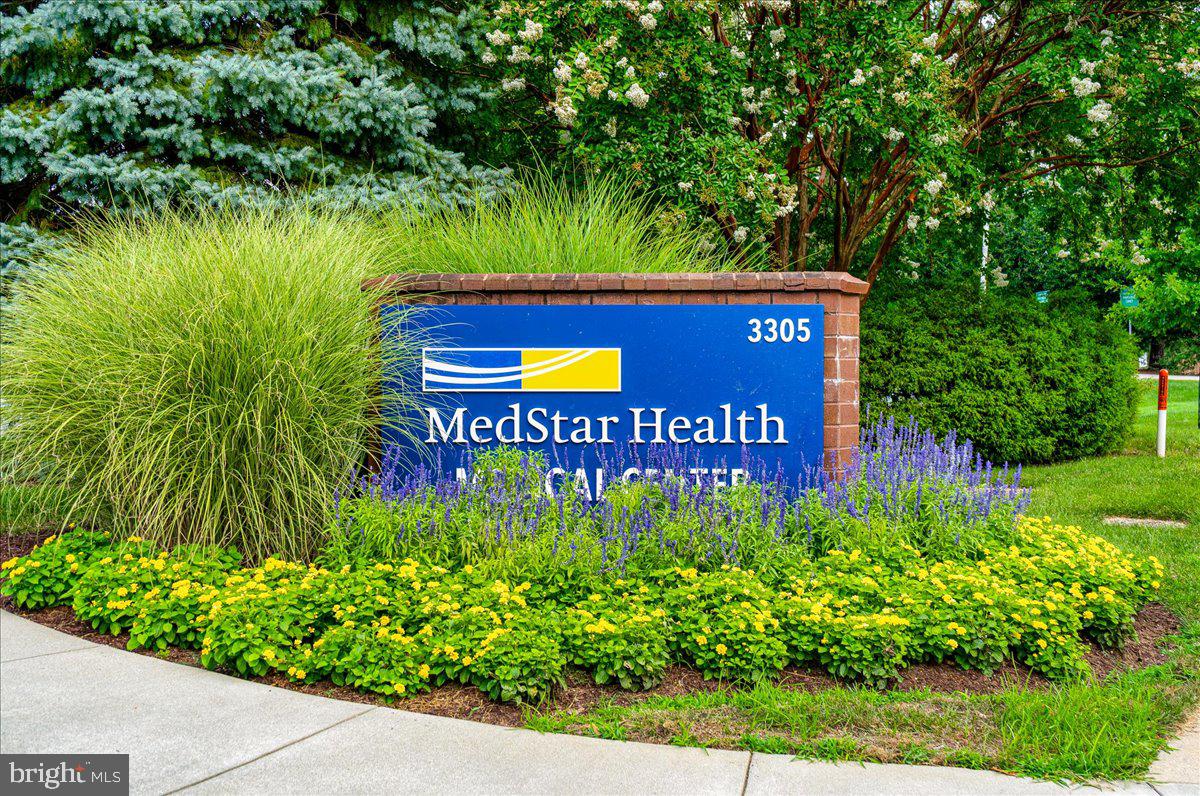 14805 Pennfield Circle, Unit 201 Silver Spring, MD 20906 - Photo 46 of 47 a sign that is sitting in front of a big yard with potted plants