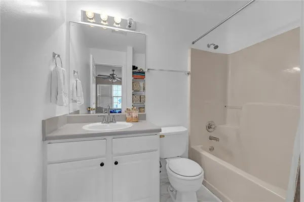 a bathroom with a sink toilet vanity and shower