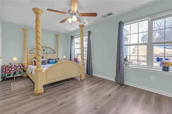 a bedroom with a bed chandelier and a window