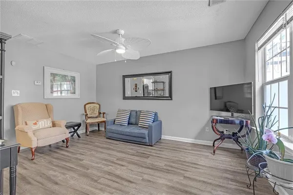 a living room with furniture flat screen tv and wooden floor