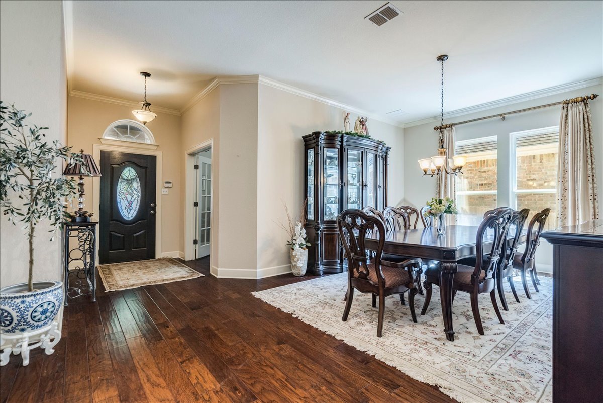 12909 Medina River Way Austin, TX 78732 - Photo 10 of 36 Rich hardwood flooring and crown molding define this formal dining space near the entryway.