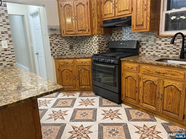 a kitchen with granite countertop a sink and cabinets