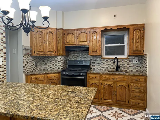 a kitchen with granite countertop a stove and cabinets