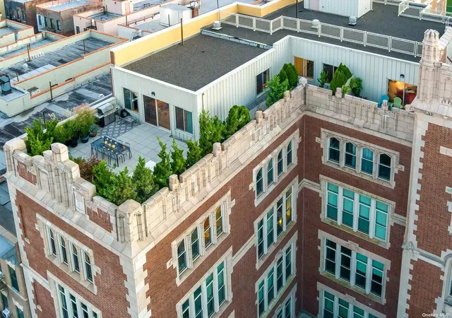 an aerial view of multi story residential apartment building with a yard and potted plants