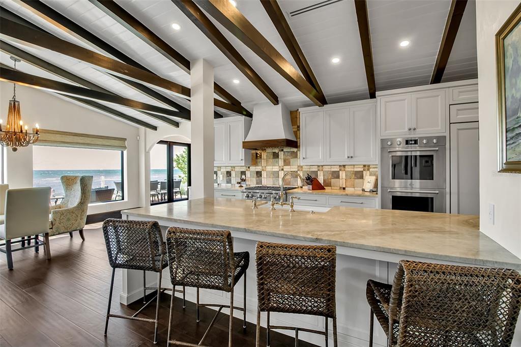 121 North Casey Key Road Osprey, FL 34229 - Photo 12 of 63 a kitchen with stainless steel appliances granite countertop a table chairs sink and cabinets