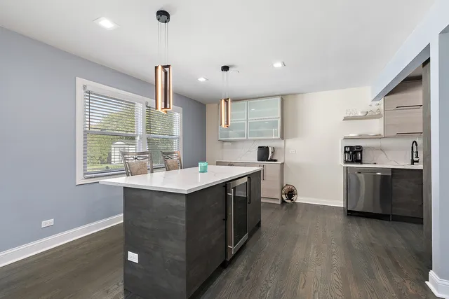 a kitchen with a sink appliances wooden floor and a window