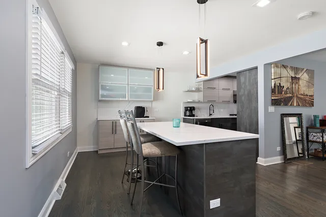 a kitchen with a table chairs refrigerator and cabinets
