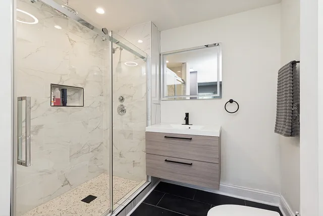 a bathroom with a shower a sink and a mirror