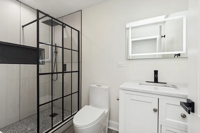 a bathroom with a sink a toilet and shower