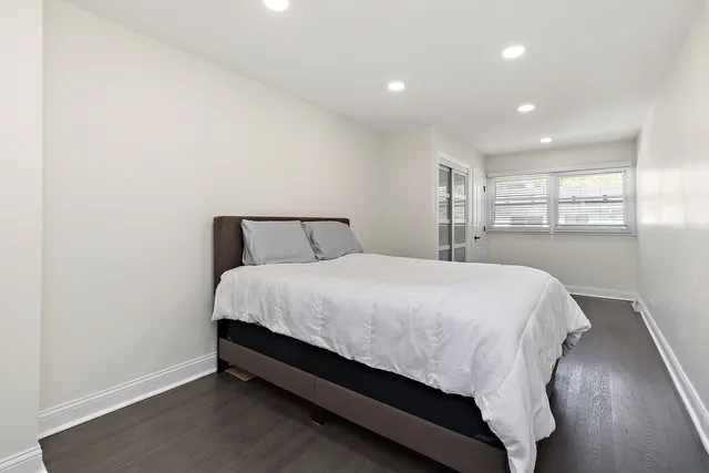 a large bed sitting in a bedroom next to a window