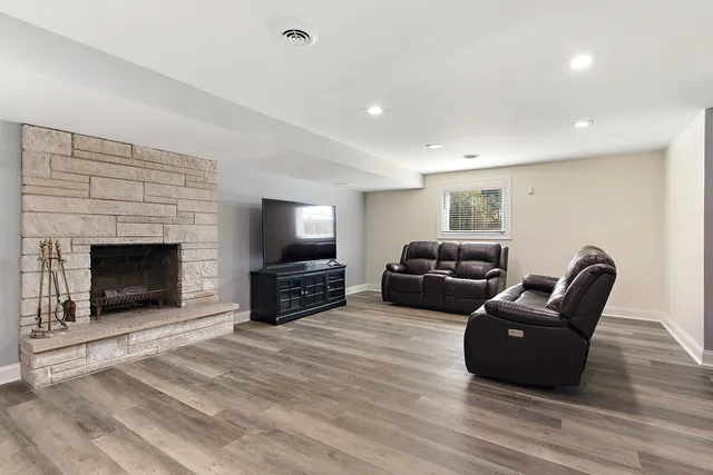 a living room with furniture a flat screen tv and a fireplace