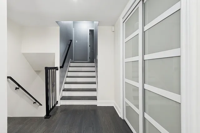 a view of a hallway with wooden floor and entryway