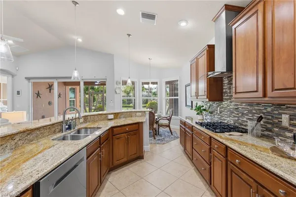 a large kitchen with kitchen island granite countertop a sink and a stove