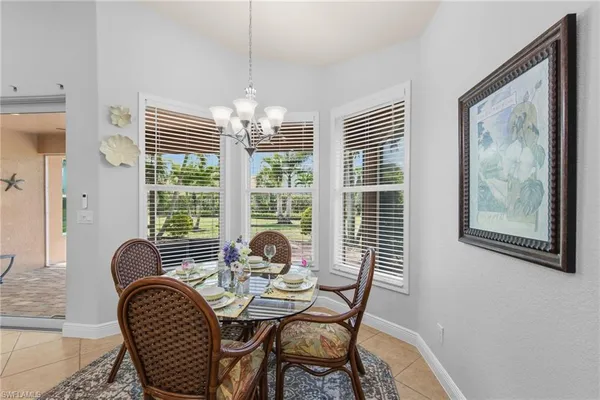 a dining room with furniture a chandelier and window