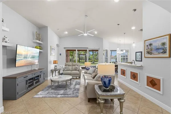 a living room with furniture a flat screen tv and a floor to ceiling window