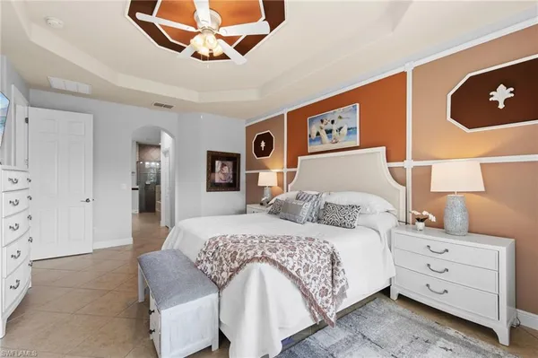 a bedroom with a bed and a lamp on the dresser