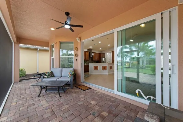 a living room with patio furniture and a floor to ceiling window