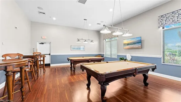 a room with stainless steel appliances table chairs and wooden floor