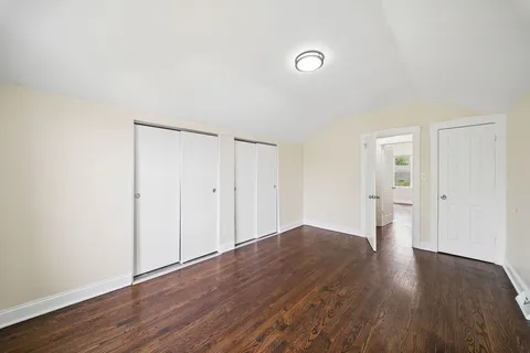 a big room with wooden floor and bathroom view