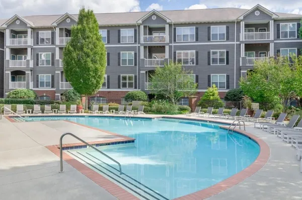 a view of a building with a swimming pool and a chairs