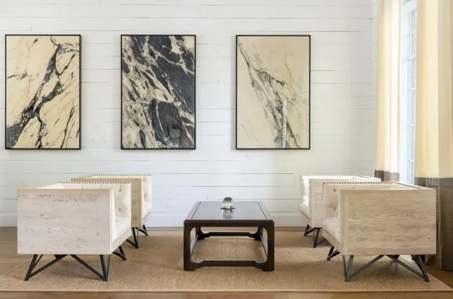 a living room with furniture and a painting on the wall