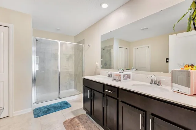 a en suite bathroom with a sink double vanity and a mirror