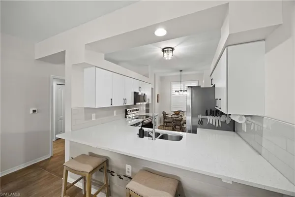 a kitchen with a dining table chairs and white cabinets