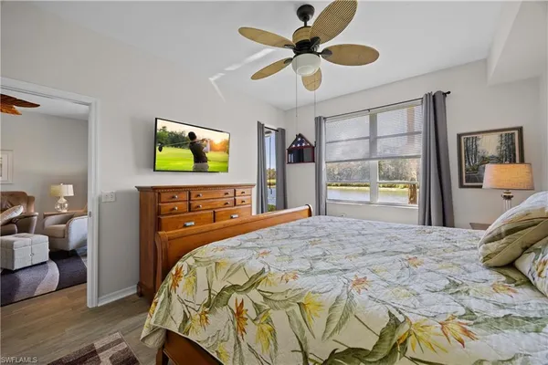a bedroom with a bed and a flat tv screen on dresser