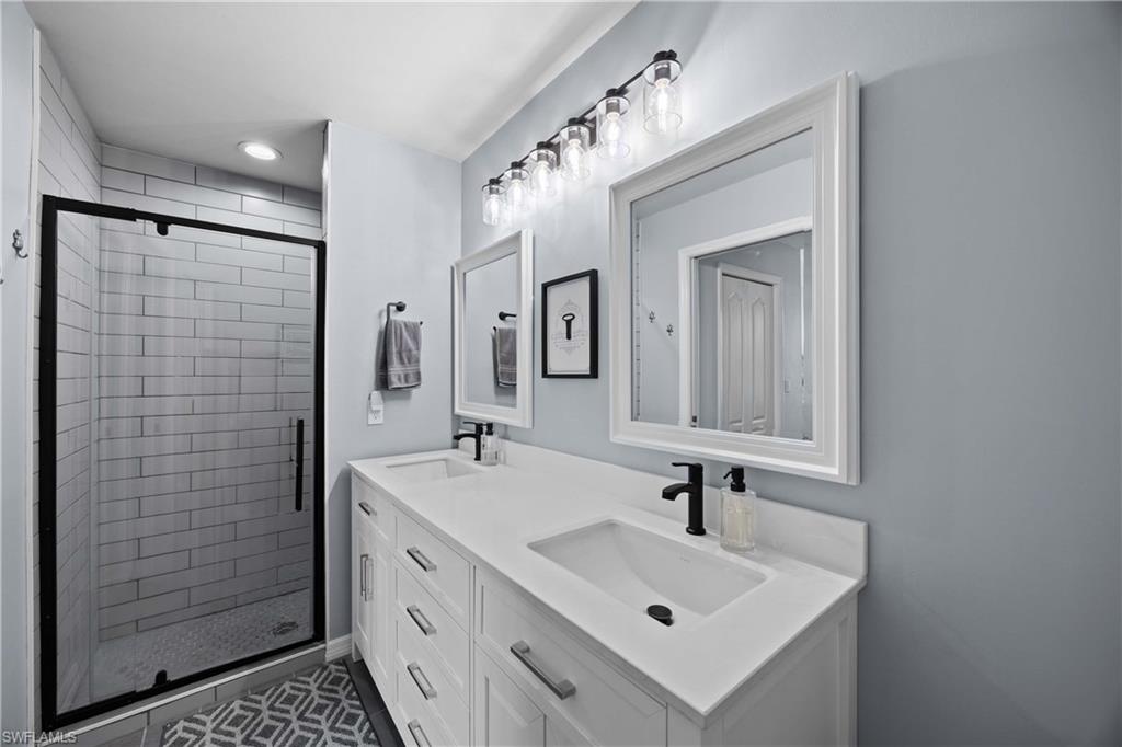 3760 Sawgrass Way, Unit 3514 Naples, FL 34112 - Photo 17 of 43 a bathroom with a sink a mirror and shower