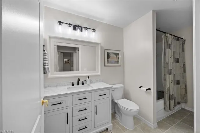 a bathroom with a toilet a sink a mirror a vanity and window