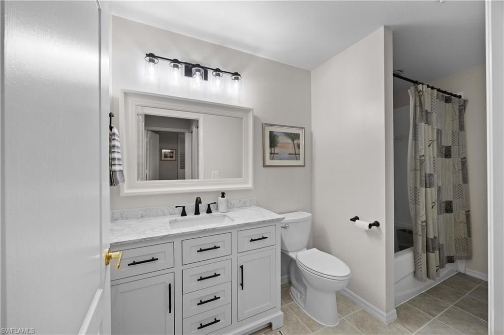 3760 Sawgrass Way, Unit 3514 Naples, FL 34112 - Photo 20 of 43 a bathroom with a toilet a sink a mirror a vanity and window