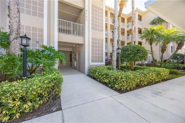 front view of a multi story residential apartment building with a yard