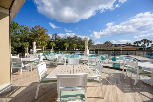 a view of a patio with couches chairs dining table and chairs with wooden floor