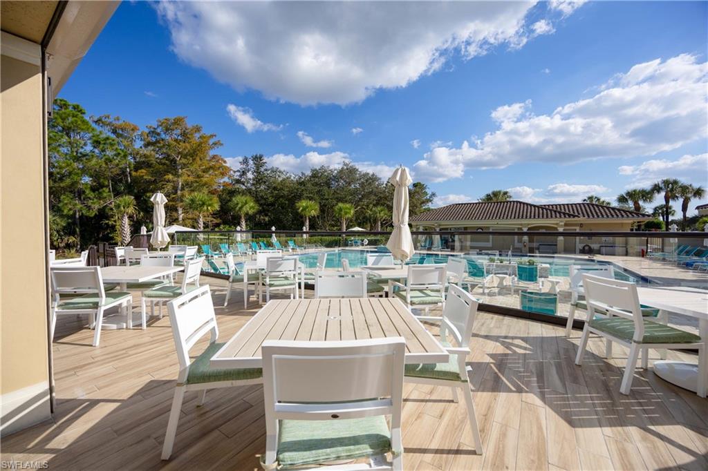 3760 Sawgrass Way, Unit 3514 Naples, FL 34112 - Photo 31 of 43 a view of a patio with couches chairs dining table and chairs with wooden floor