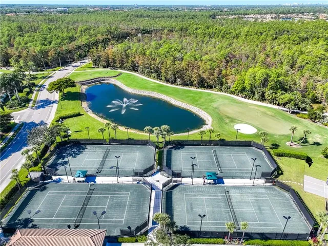 a view of a tennis ground with large trees