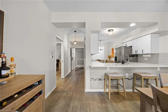 a kitchen with stainless steel appliances a table and chairs in it