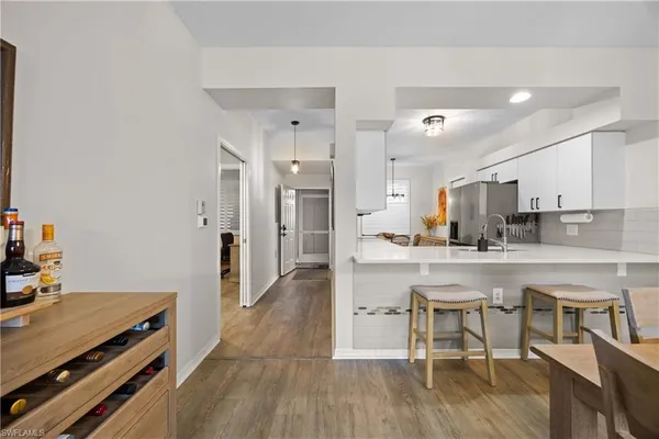 a kitchen with stainless steel appliances a table and chairs in it