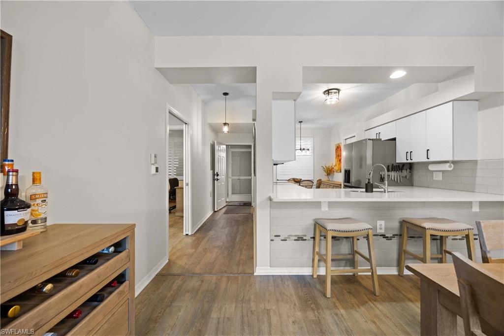 3760 Sawgrass Way, Unit 3514 Naples, FL 34112 - Photo 5 of 43 a kitchen with stainless steel appliances a table and chairs in it