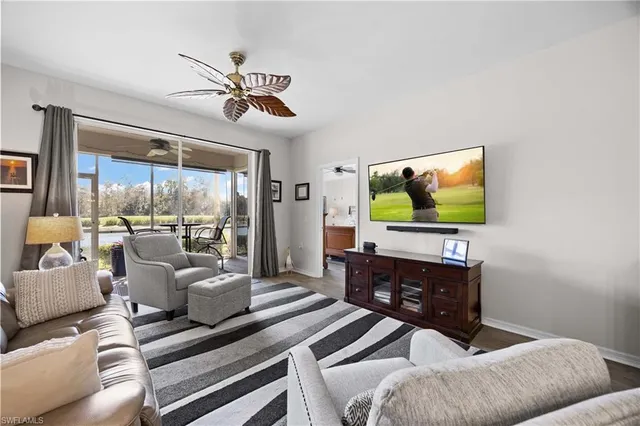 a living room with furniture a flat screen tv and a floor to ceiling window