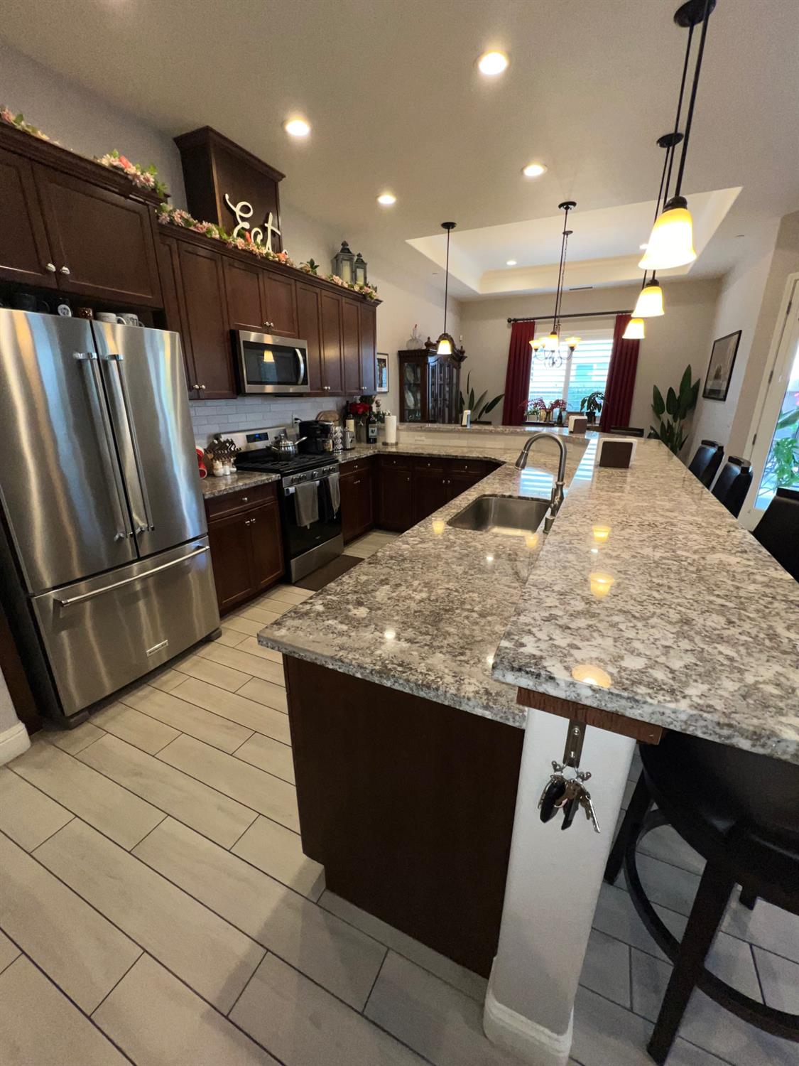 889 Coloma Place Madera, CA 93637 - Photo 13 of 61 a kitchen with kitchen island a counter top space appliances and a ceiling fan