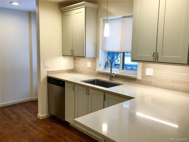a kitchen with a sink cabinets and wooden floor