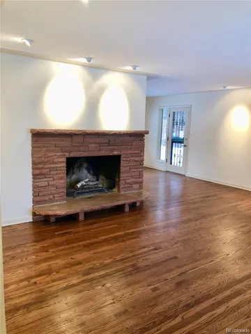 a living room with wooden floors and a fireplace
