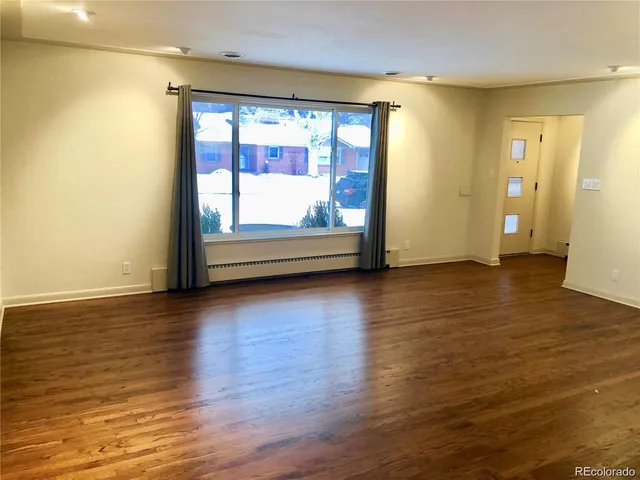 a view of room with window and wooden floor