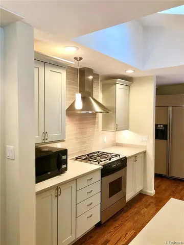 a kitchen with stainless steel appliances a stove and a microwave