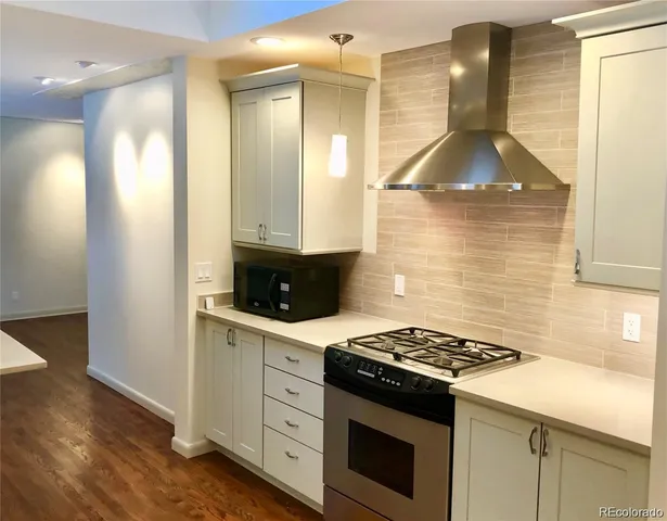 a kitchen with a stove and a wooden cabinets