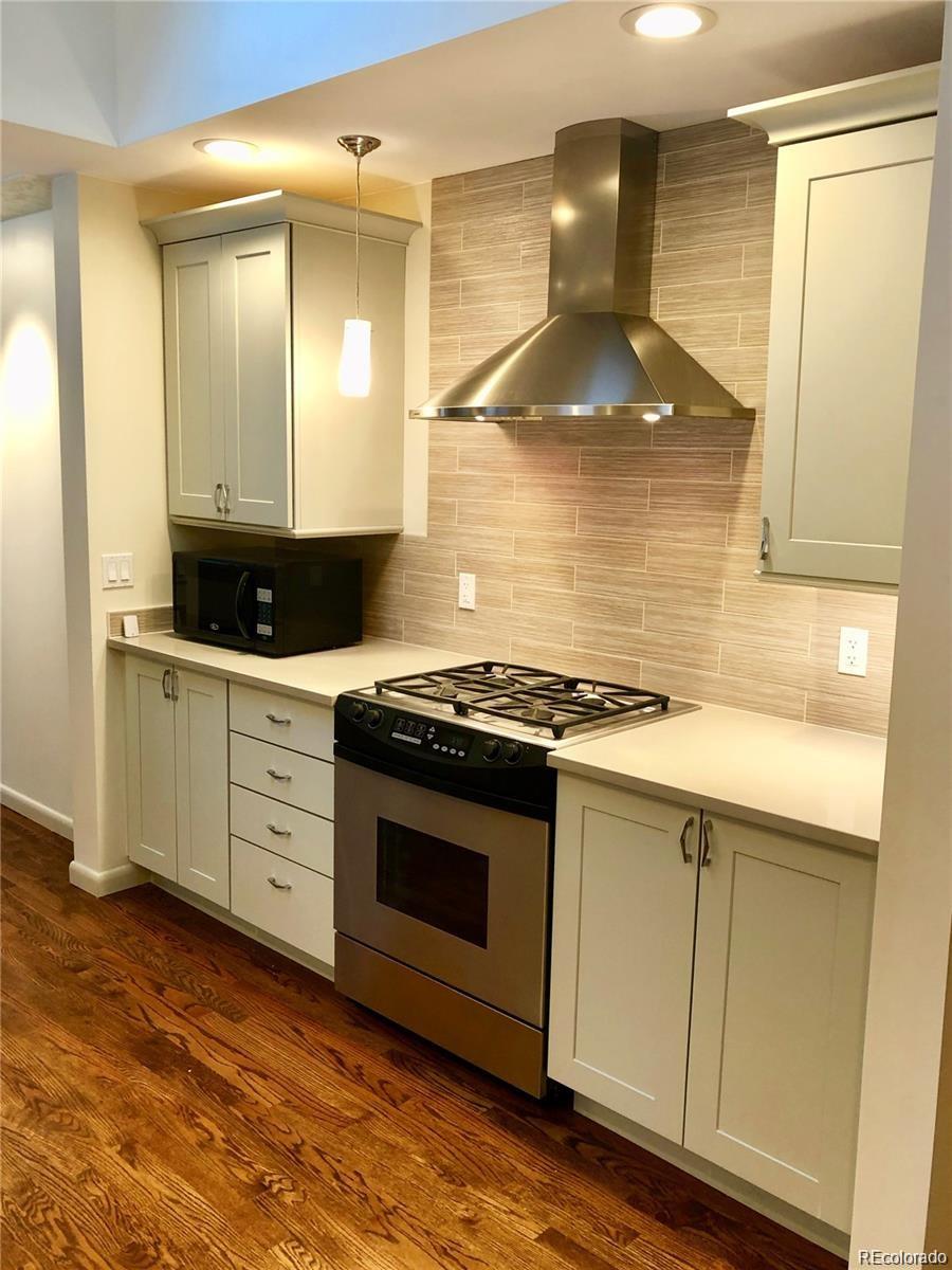 3022 South Gilpin Street Denver, CO 80210 - Photo 9 of 28 a kitchen with stainless steel appliances granite countertop a stove a sink and a microwave