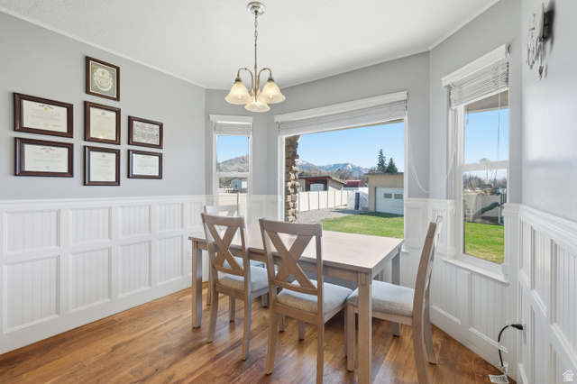 860 West 2980th Street South Logan, UT 84321 - Photo 12 of 38 Dining area featuring wood-finish flooring, white wainscoting, and large windows