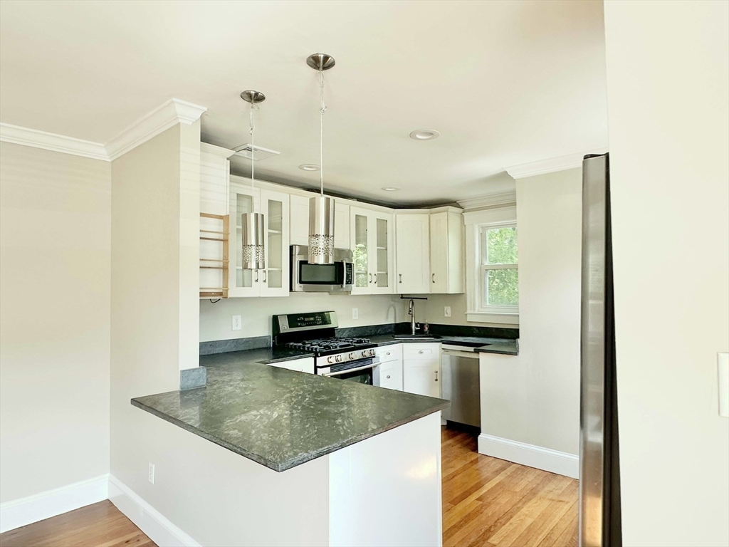 8 A Mellon Road Wellesley, MA 02482 - Photo 4 of 22 a kitchen with stainless steel appliances granite countertop a sink a stove and a refrigerator